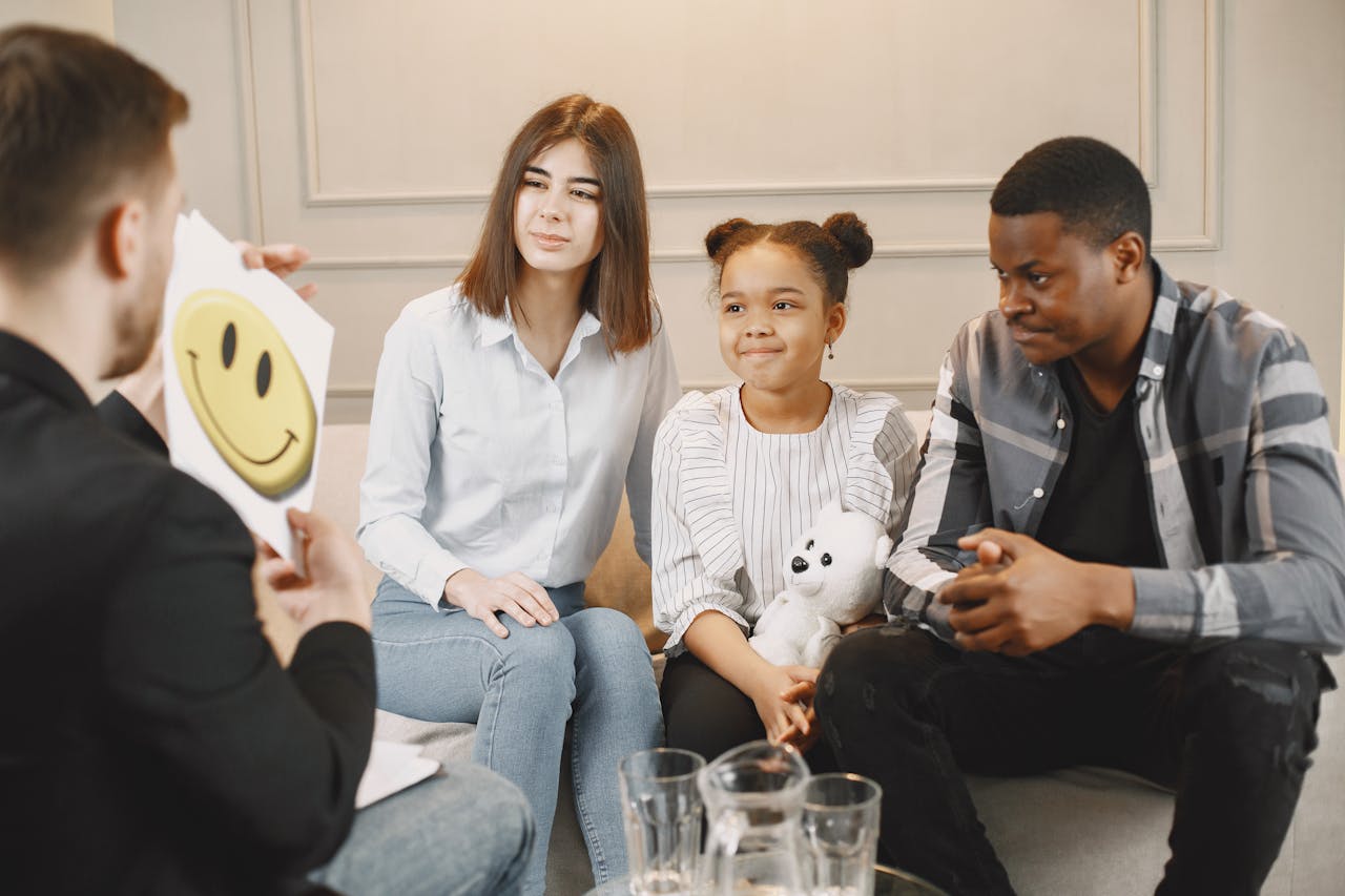 A family therapy session with a therapist, featuring parents and a child engaging in discussion.